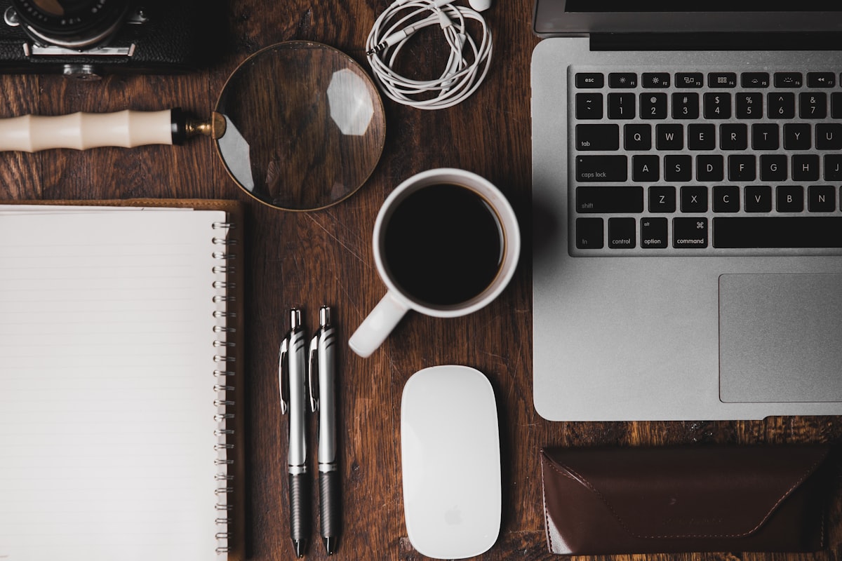 Bureau de travail ordonné avec ordinateur portable, carnet et tasse de café
